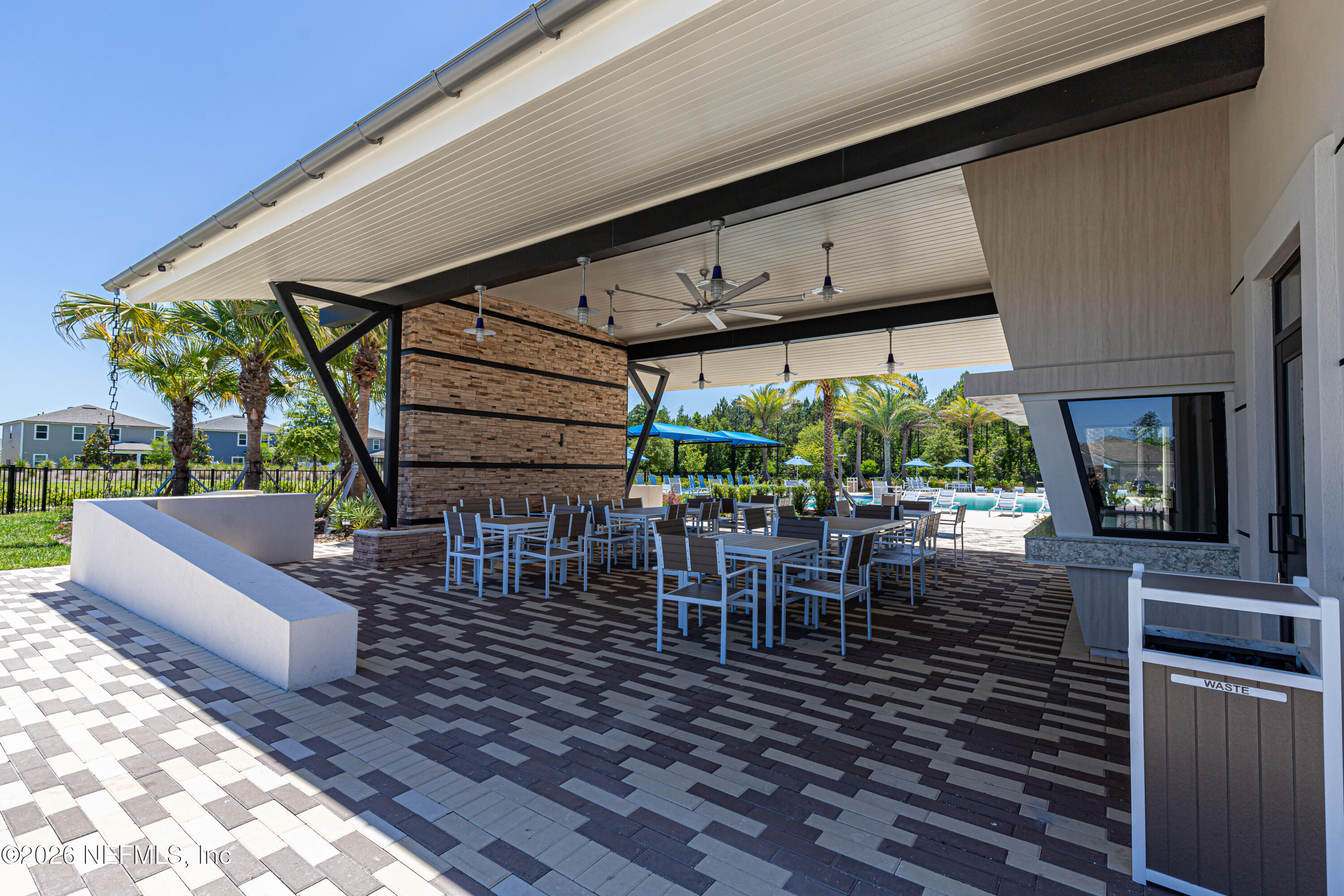 12068 Calvesta Street Jacksonville, FL 32256 - Photo 62 of 100 a view of a patio with table and chairs potted plants and floor to ceiling window