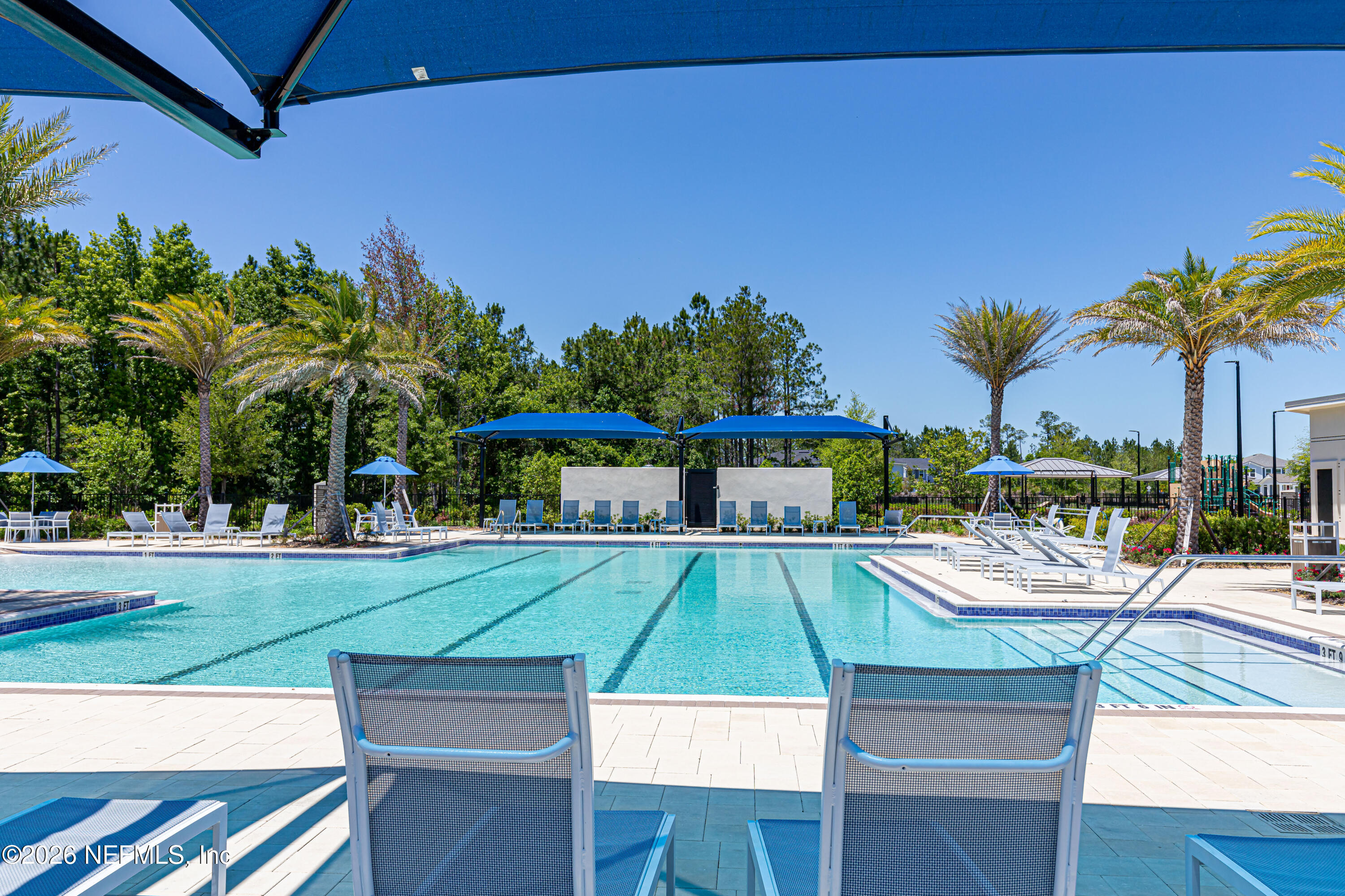 12068 Calvesta Street Jacksonville, FL 32256 - Photo 65 of 100 a view of a swimming pool with a lawn chairs under an umbrella