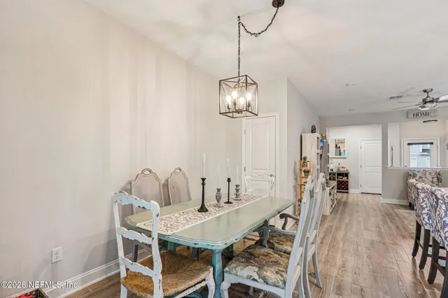 a living room with furniture and a dining table with kitchen appliances