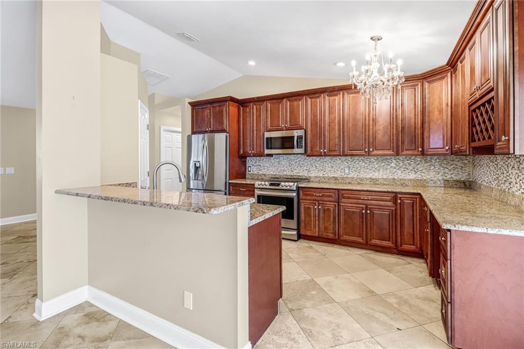 8116 Sandpiper Road Fort Myers, FL 33967 - Photo 11 of 29 Kitchen featuring backsplash, appliances with stainless steel finishes, a chandelier, and light tile floors