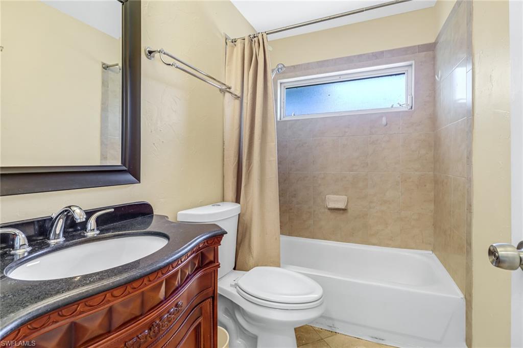 8116 Sandpiper Road Fort Myers, FL 33967 - Photo 17 of 29 Full bathroom with tile flooring, toilet, oversized vanity, and shower / bath combo with shower curtain