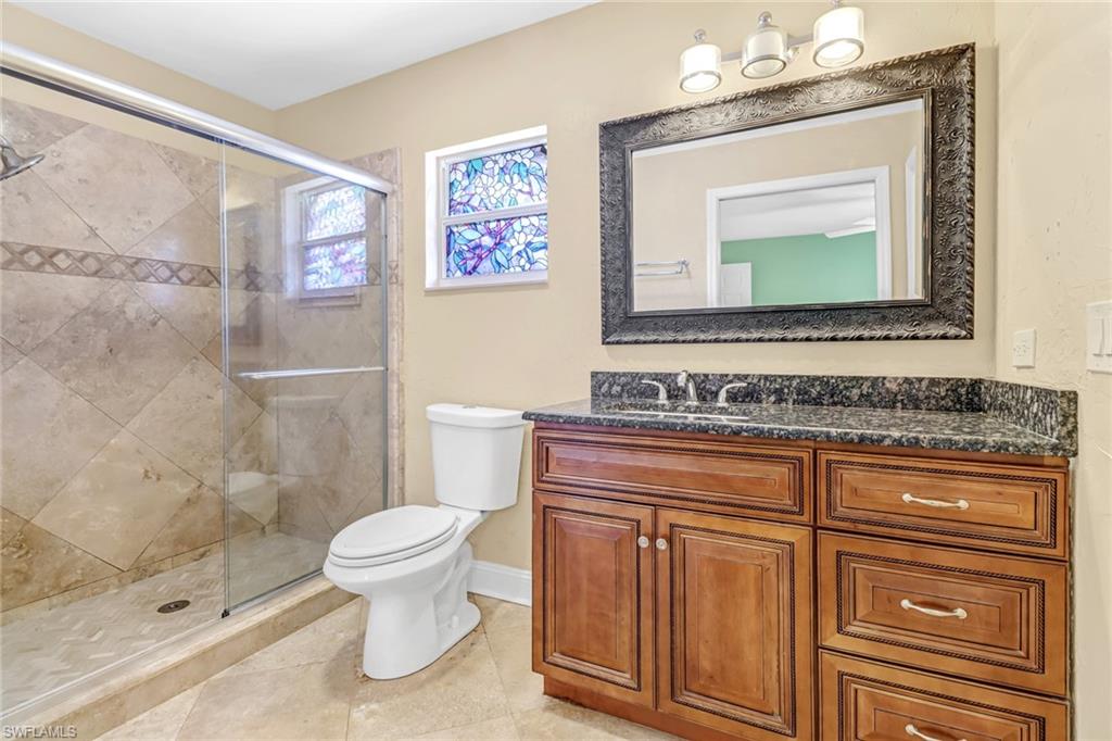 8116 Sandpiper Road Fort Myers, FL 33967 - Photo 20 of 29 Bathroom with vanity, toilet, tile floors, and a shower with door