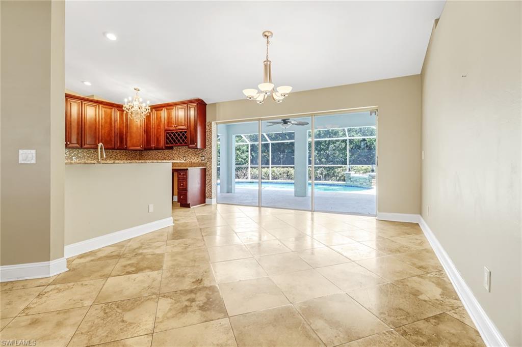 8116 Sandpiper Road Fort Myers, FL 33967 - Photo 6 of 29 Kitchen with ceiling fan with notable chandelier, tasteful backsplash, light tile floors, and pendant lighting