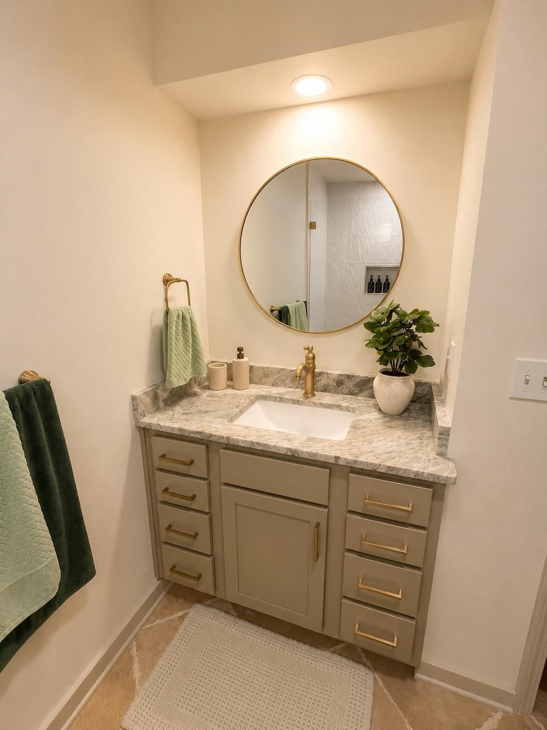 470 Rich Road Somerville, TN 38068 - Photo 28 of 40 Vanity with undermount sink set in a light-toned countertop, complemented by a large circular mirror and brass-finish fixtures