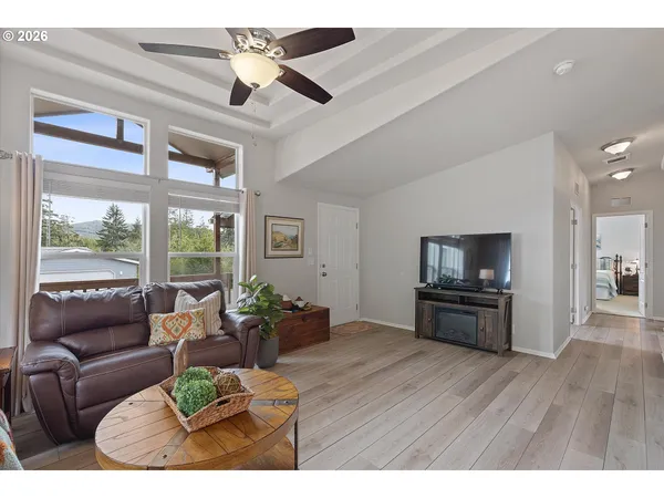 a living room with furniture kitchen view and a wooden floor