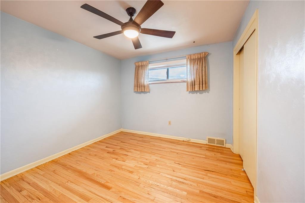 430 Amherst Avenue Coraopolis, PA 15108 - Photo 17 of 33 a view of a big room with wooden floor and a ceiling fan
