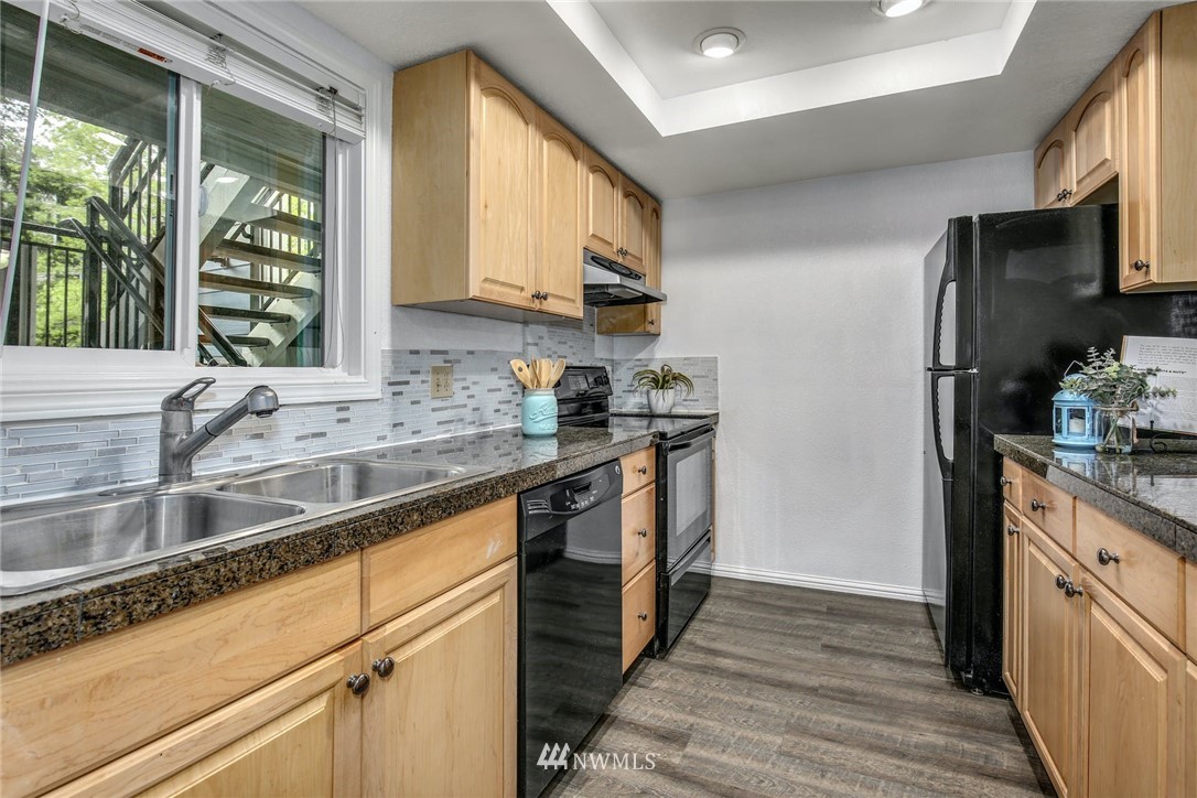7571 Old Redmond Road, Unit 11 Redmond, WA 98052 - Photo 9 of 27 a kitchen with stainless steel appliances granite countertop a sink a stove and a refrigerator