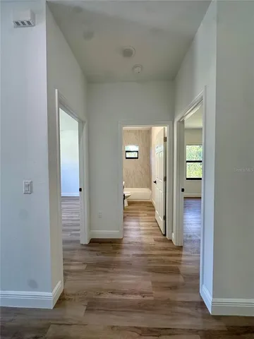 a view of a hallway with wooden floor