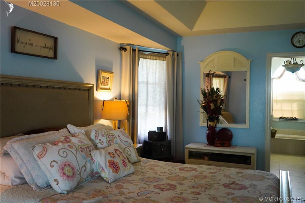 7302 Santa Rosa Parkway Fort Pierce, FL 34951 - Photo 30 of 33 a bedroom with a bed and a potted plant on the dresser