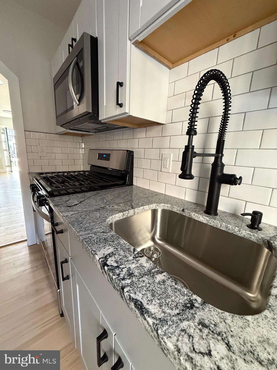 1263 South Merrimac Road Camden, NJ 08104 - Photo 15 of 16 a kitchen with a stove a sink and a microwave