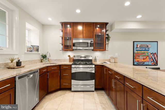 a kitchen with stainless steel appliances granite countertop a stove sink and cabinets