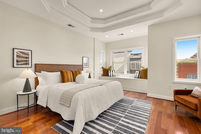 a bedroom with double bed a couch and a large window