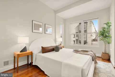 a bedroom with a bed and wooden floor