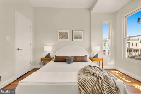 a bedroom with a bed and wooden floor