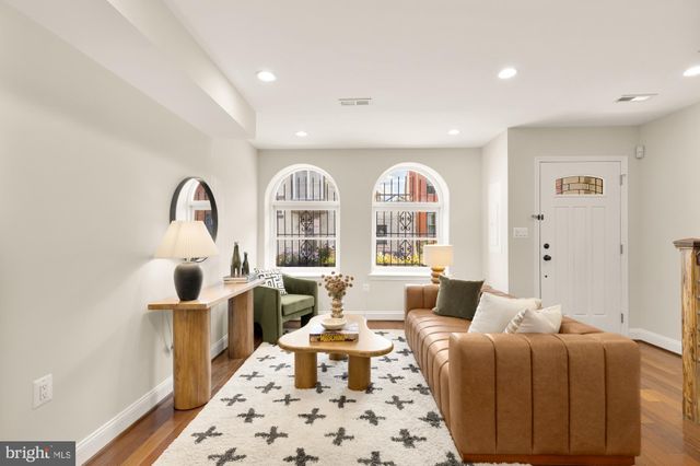 a living room with furniture fireplace and wooden floor