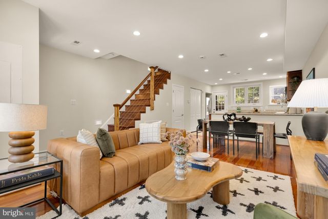 a living room with furniture and a dining table with kitchen view