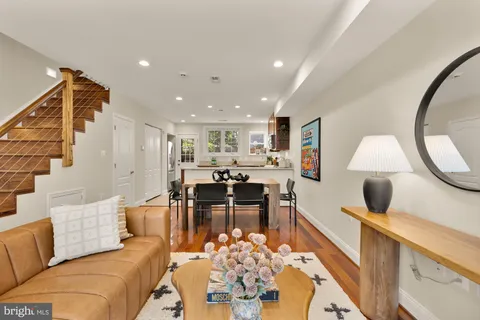 a living room with furniture kitchen view and a large mirror