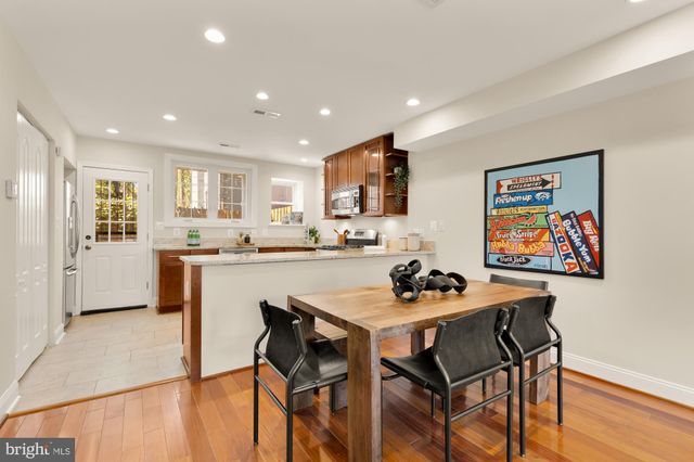 a kitchen with a dining table chairs and refrigerator
