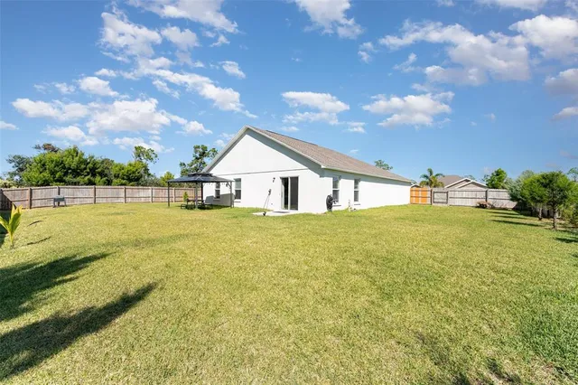 a house view with swimming pool and trees in the background