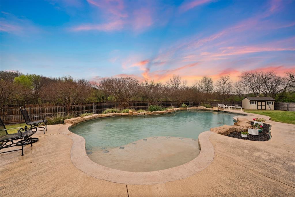 517 Chado Lane Robinson, TX 76706 - Photo 38 of 40 Pool at dusk with a fenced backyard, a patio area, and a storage unit