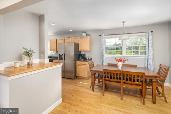 a dining room with a table chairs and a kitchen view
