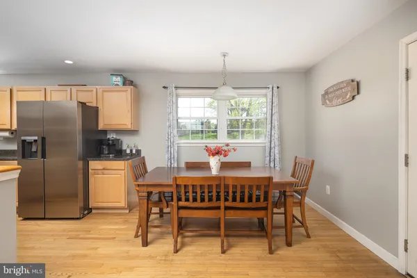 a dining room with furniture a chandelier and wooden floor