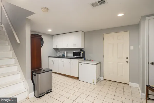 a kitchen with a refrigerator and white cabinets