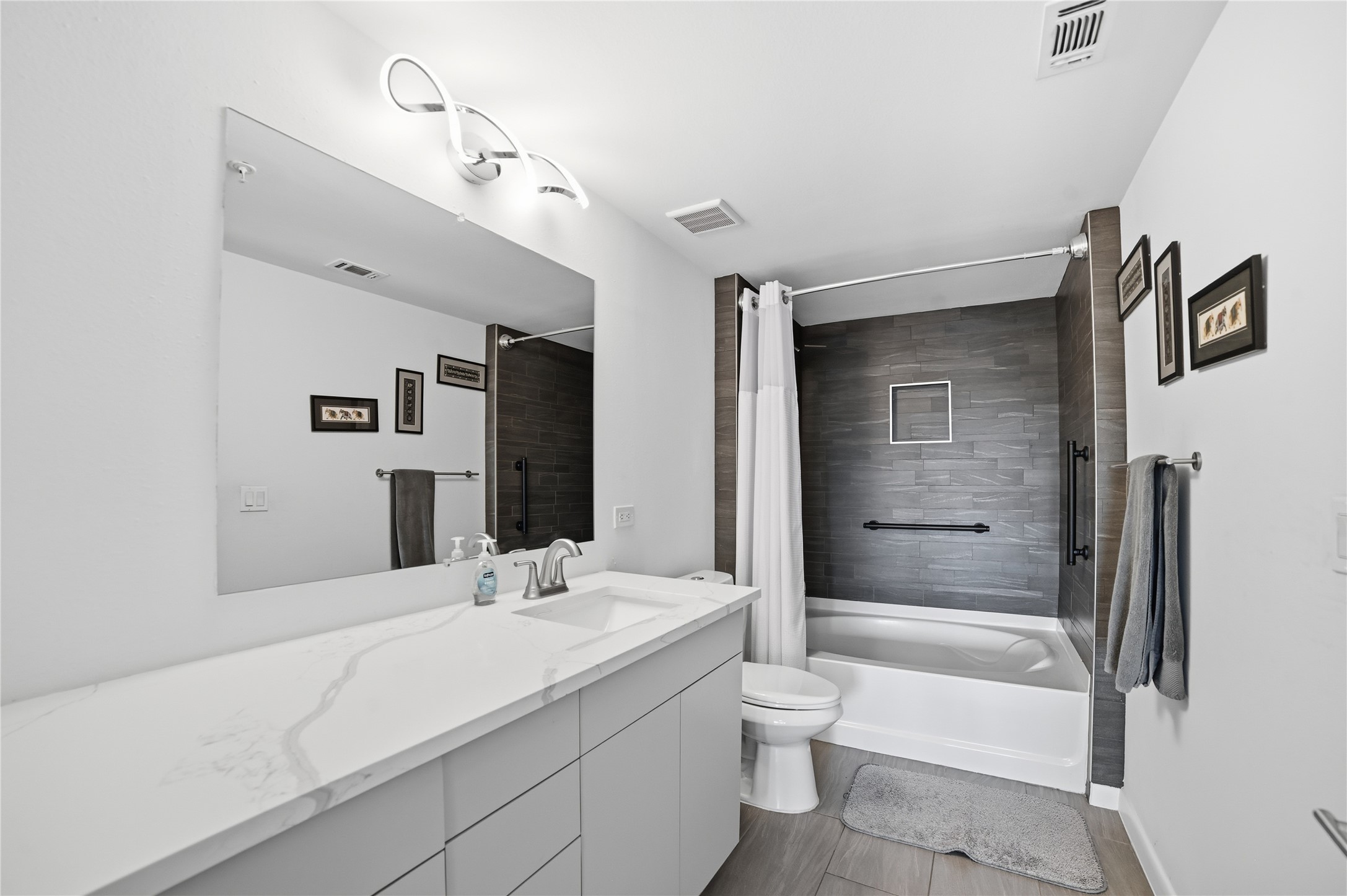 54 Rainey Street, Unit 1018 Austin, TX 78701 - Photo 22 of 32 a bathroom with a granite countertop sink a toilet and bathtub