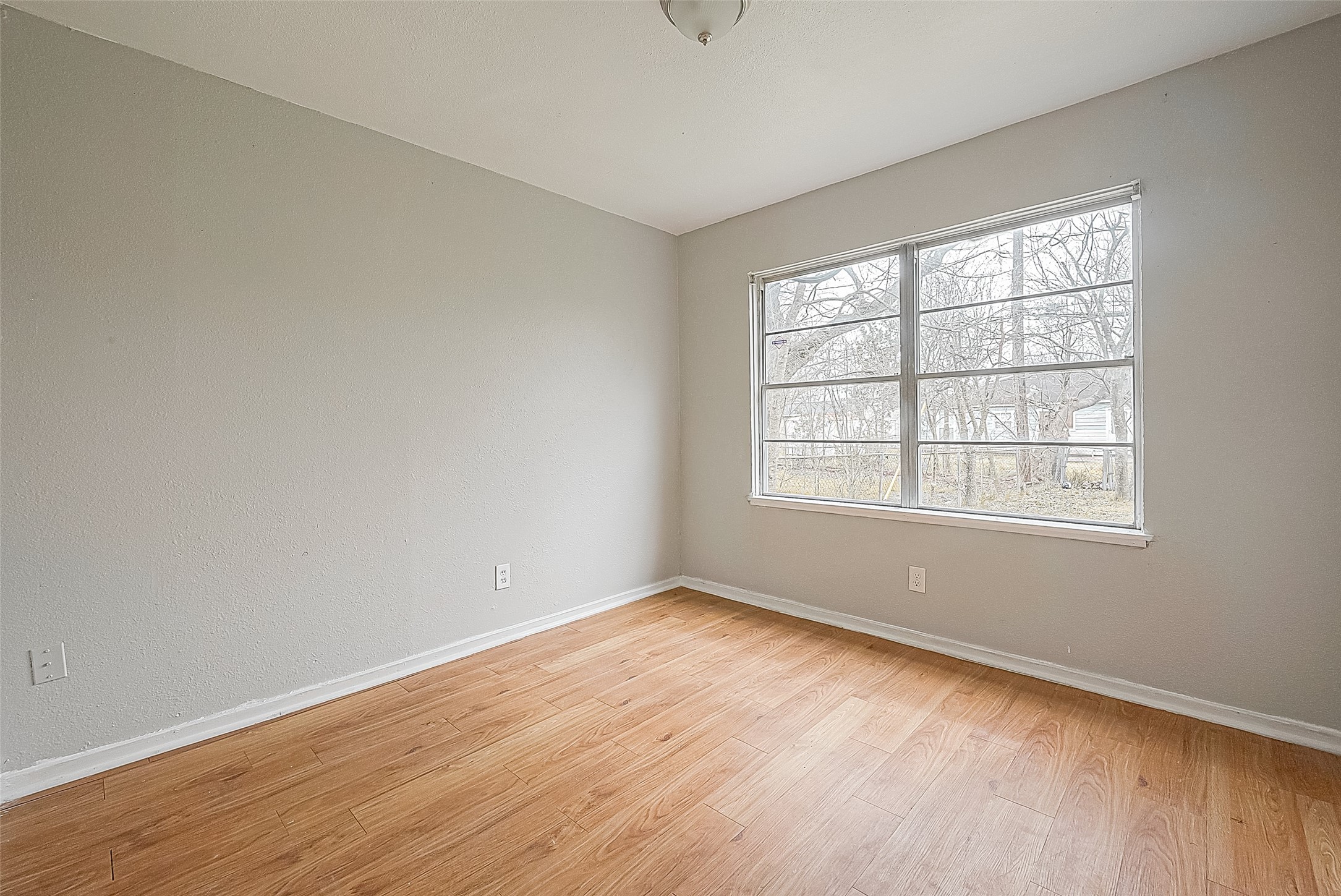 4910 Paradise Lane Houston, TX 77048 - Photo 13 of 15 an empty room with wooden floor and windows