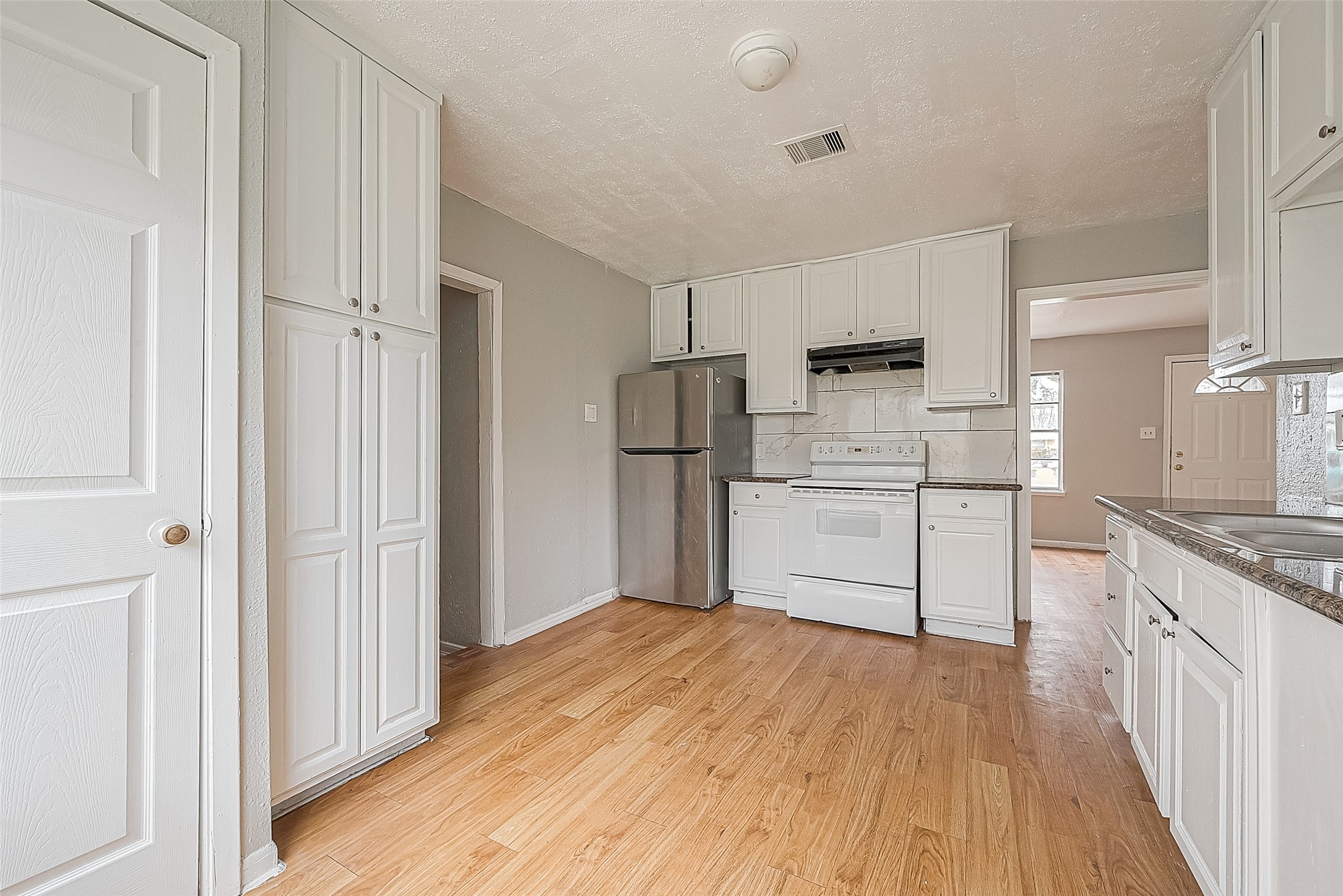 4910 Paradise Lane Houston, TX 77048 - Photo 4 of 15 a kitchen with a refrigerator sink and cabinets