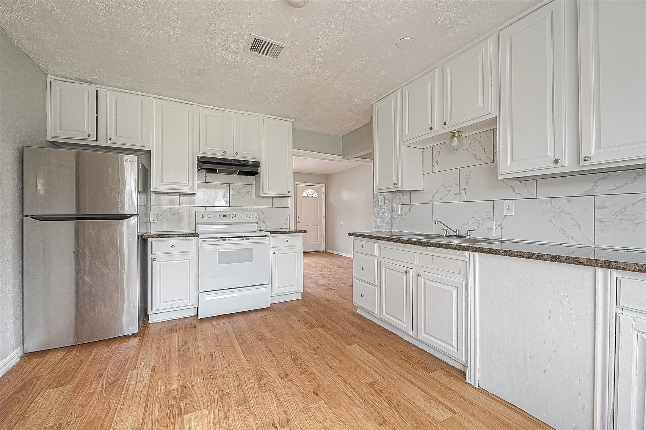 4910 Paradise Lane Houston, TX 77048 - Photo 5 of 15 a kitchen with white cabinets white stainless steel appliances and sink
