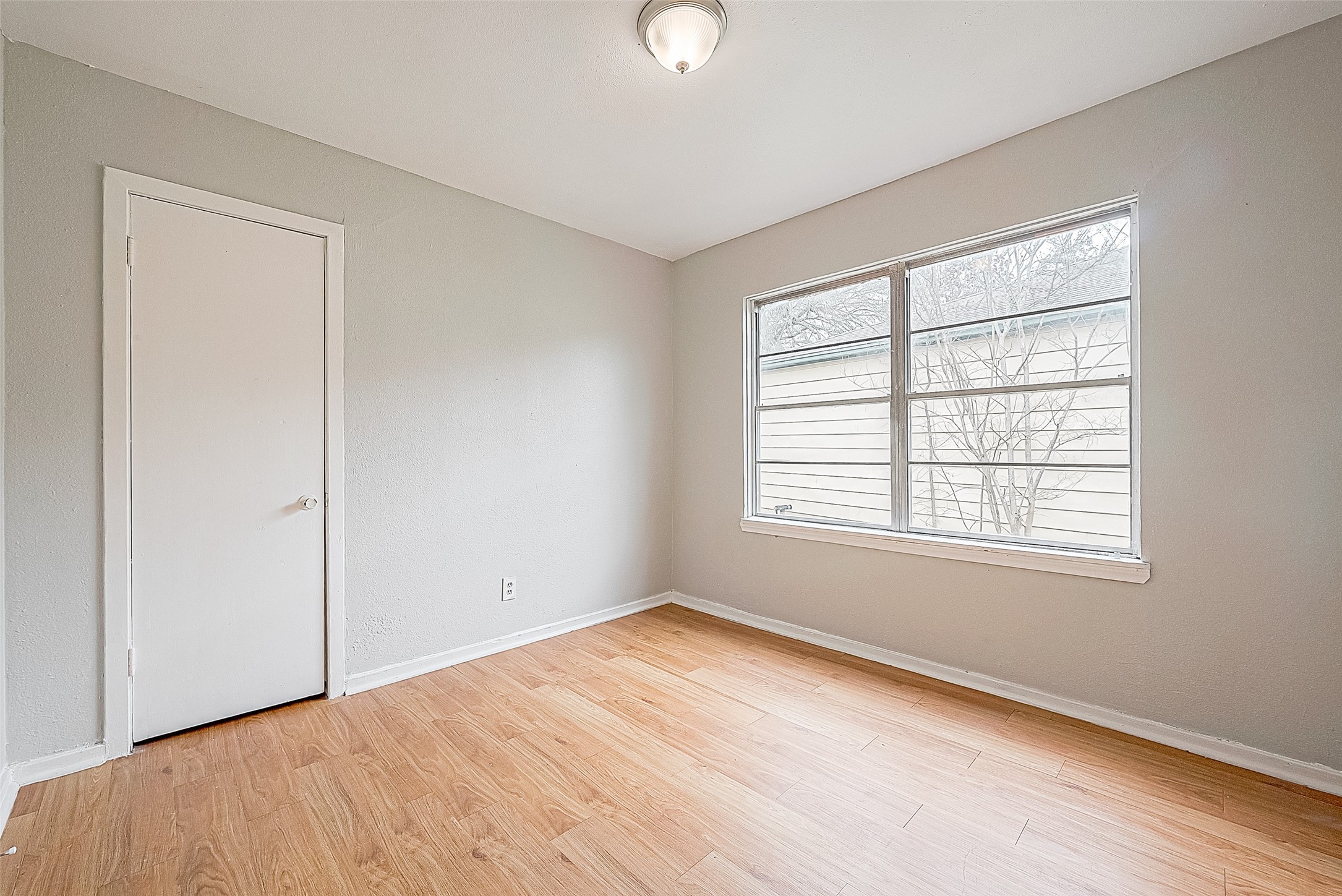 4910 Paradise Lane Houston, TX 77048 - Photo 9 of 15 an empty room with wooden floor and windows