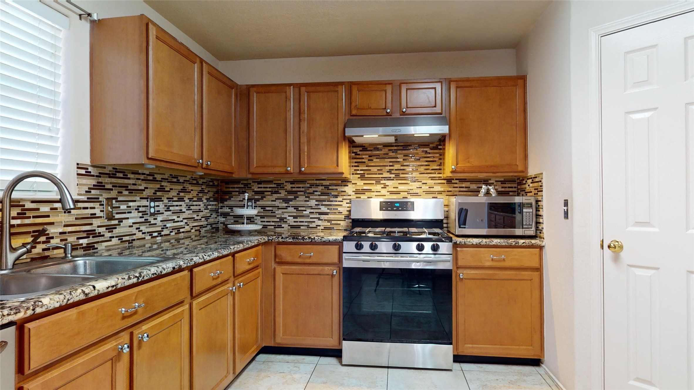 18226 Thicket Grove Road Houston, TX 77084 - Photo 9 of 45 a kitchen with stainless steel appliances granite countertop a stove and a sink