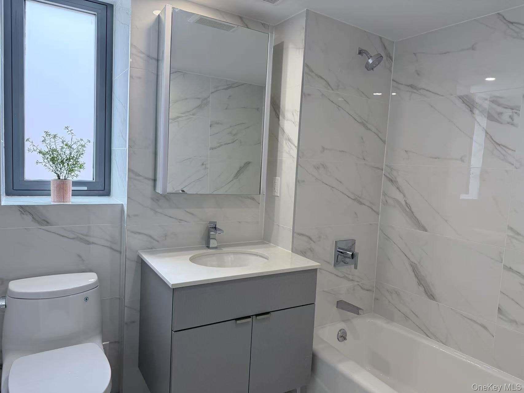 136-80 41st Avenue, Unit 7D Queens, NY 11355 - Photo 5 of 6 Bathroom featuring tile walls, vanity, and shower / bathtub combination