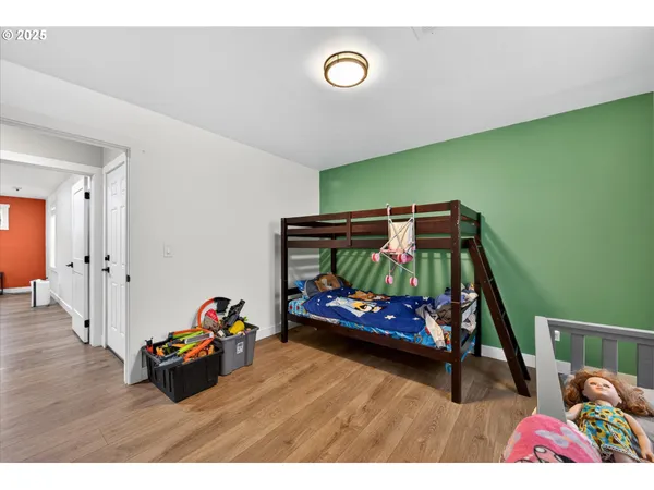 a bedroom with a bed and a wooden floor