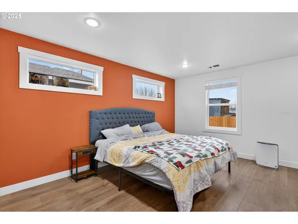 a bedroom with a bed and a painting on the wall