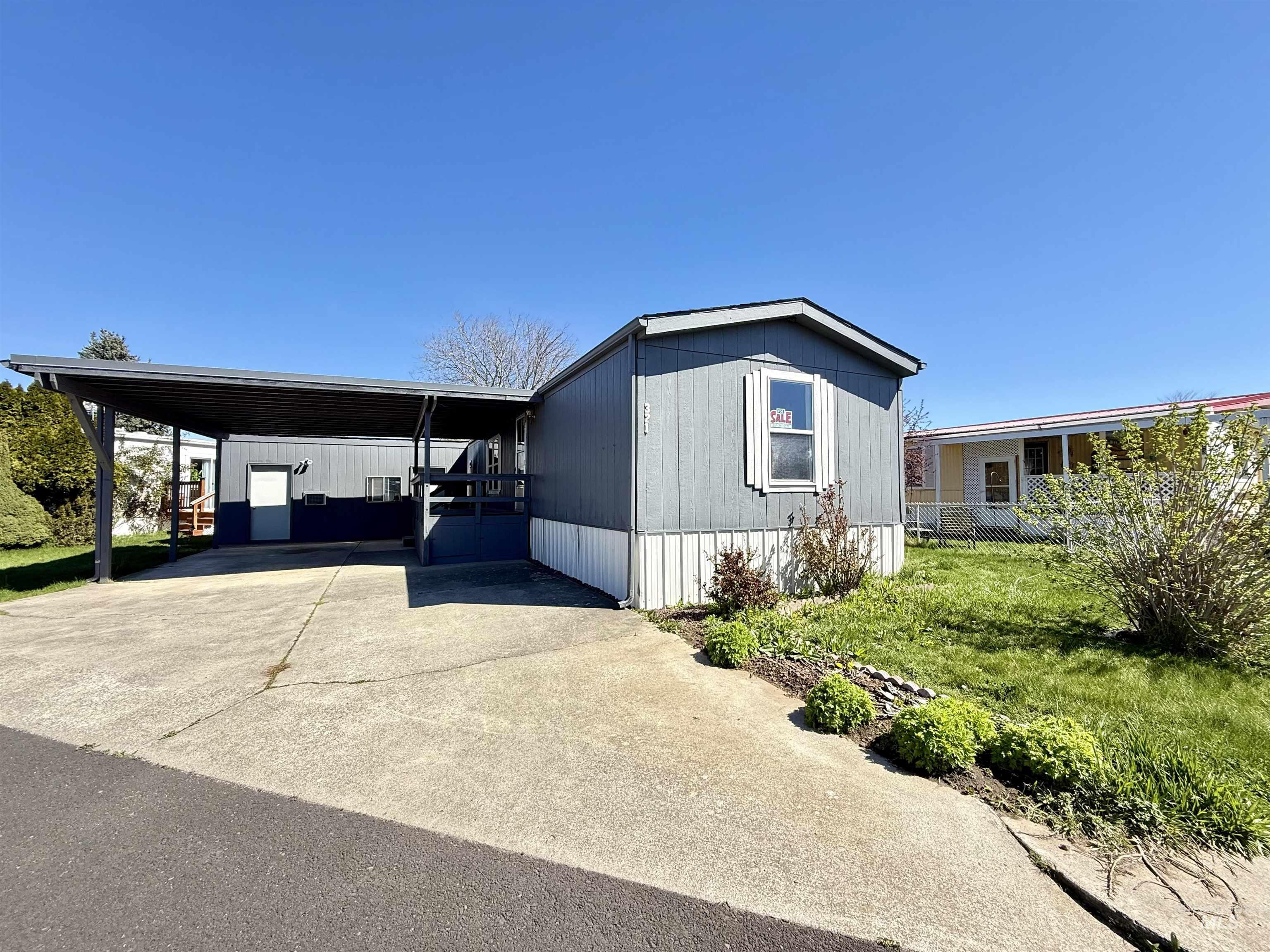 2015 6th Avenue, Unit 321 Clarkston, WA 99403 - Photo 1 of 34 Manufactured / mobile home featuring driveway, a carport, and a front lawn