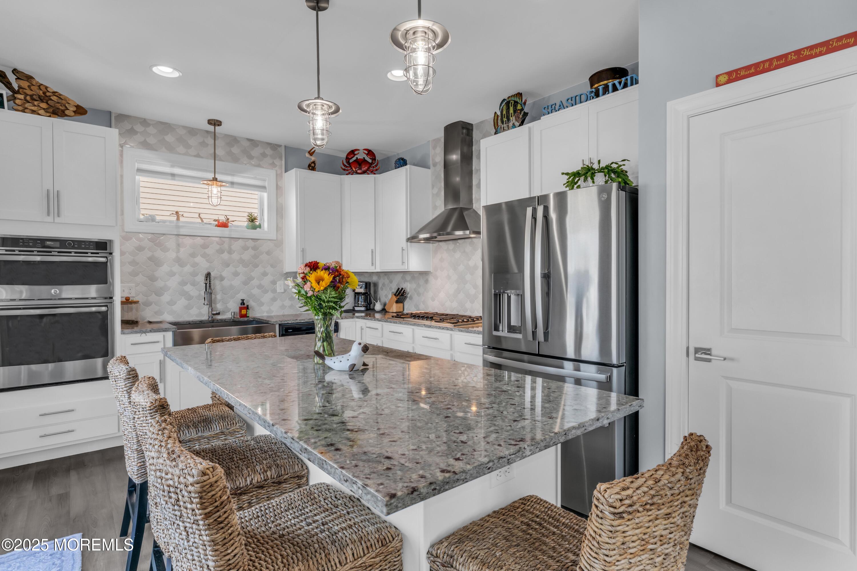 21 Compass Road Waretown, NJ 08758 - Photo 11 of 46 a kitchen with granite countertop a refrigerator a stove and white cabinets with wooden floors