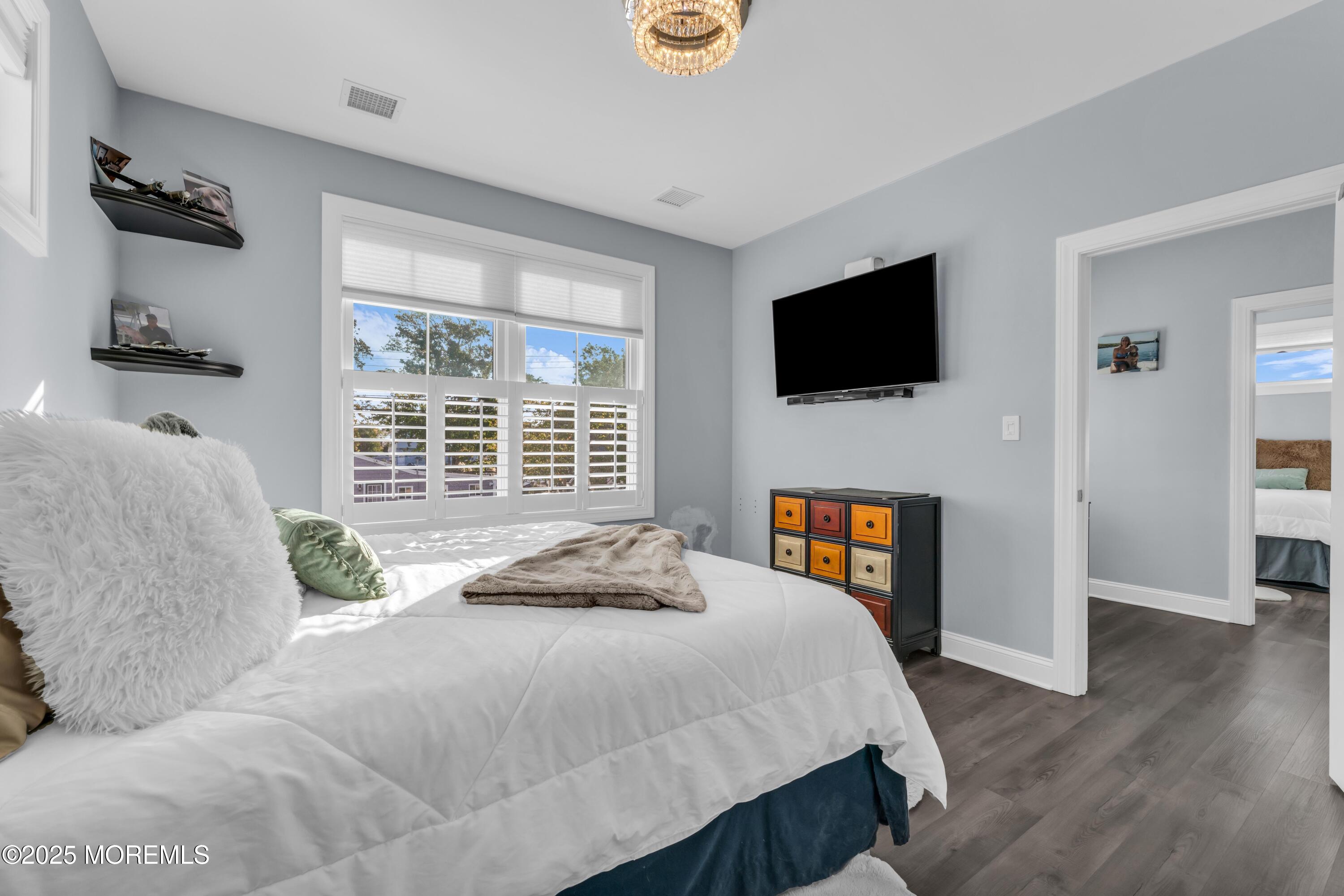 21 Compass Road Waretown, NJ 08758 - Photo 20 of 46 a bedroom with a bed a flat screen tv and a large window