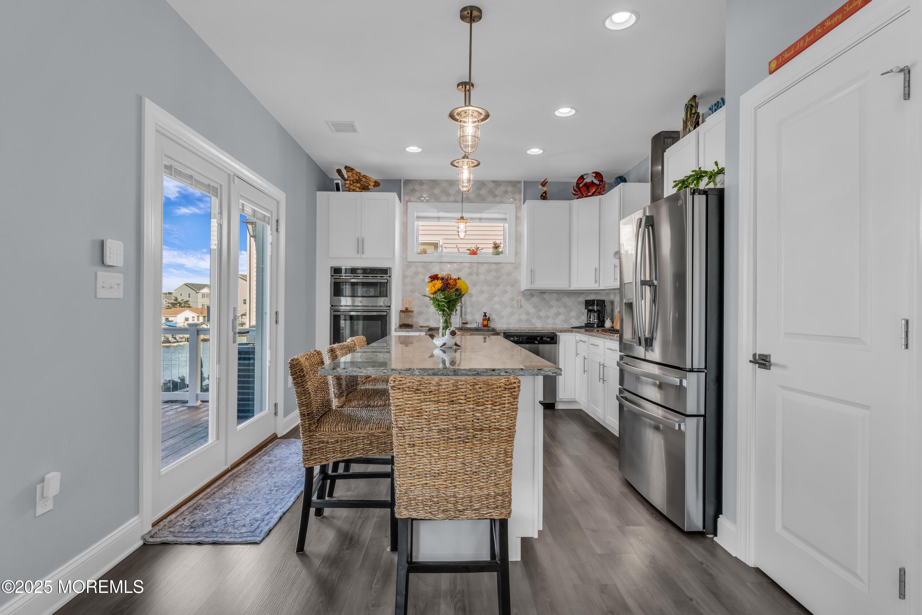 21 Compass Road Waretown, NJ 08758 - Photo 10 of 46 a view of kitchen with refrigerator microwave and wooden floor