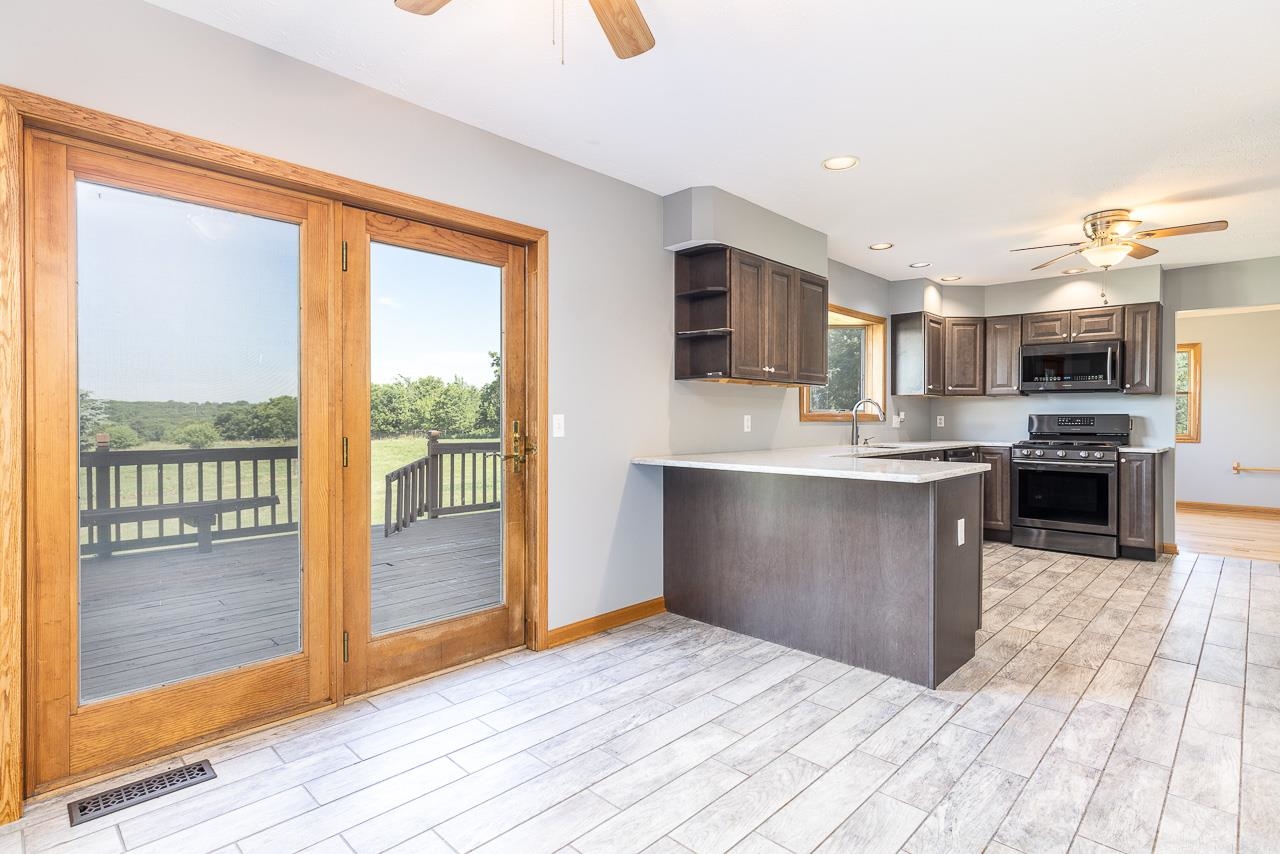 4661 North Marrill Road Byron, IL 61010 - Photo 12 of 39 a large kitchen with kitchen island a large counter space and stainless steel appliances