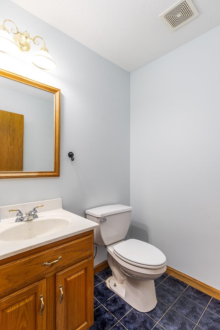 4661 North Marrill Road Byron, IL 61010 - Photo 13 of 39 a bathroom with a toilet a sink and mirror