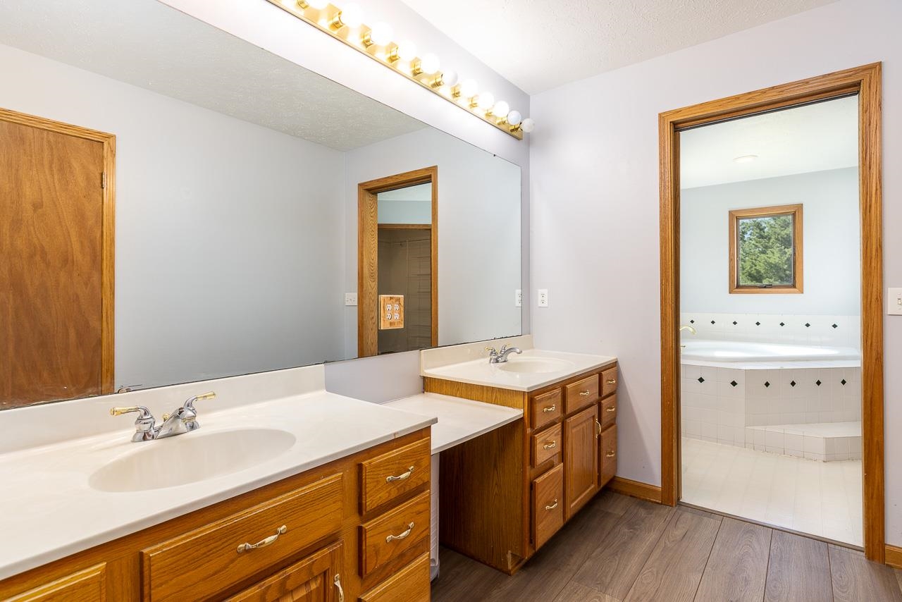 4661 North Marrill Road Byron, IL 61010 - Photo 17 of 39 a spacious bathroom with a granite countertop sink and a mirror