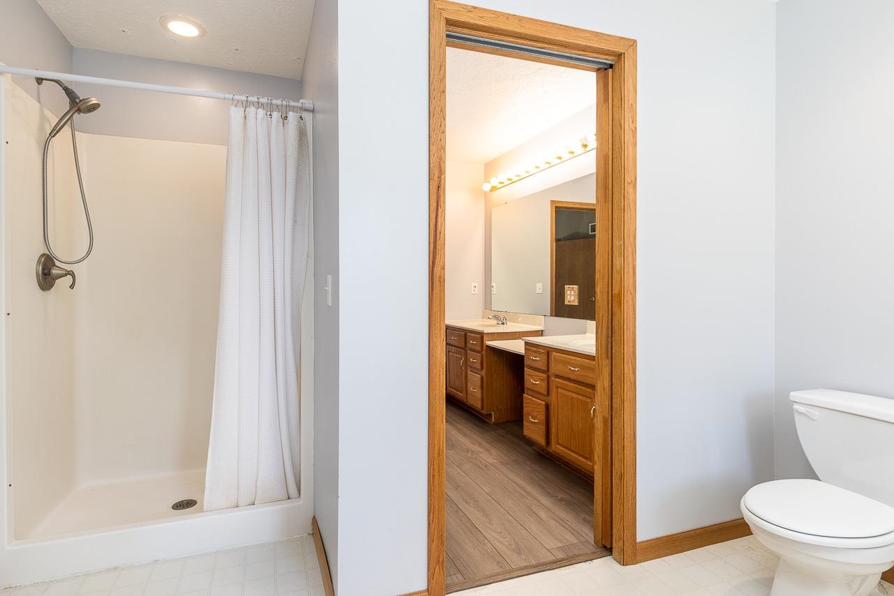 4661 North Marrill Road Byron, IL 61010 - Photo 19 of 39 a bathroom with a granite countertop sink toilet and shower