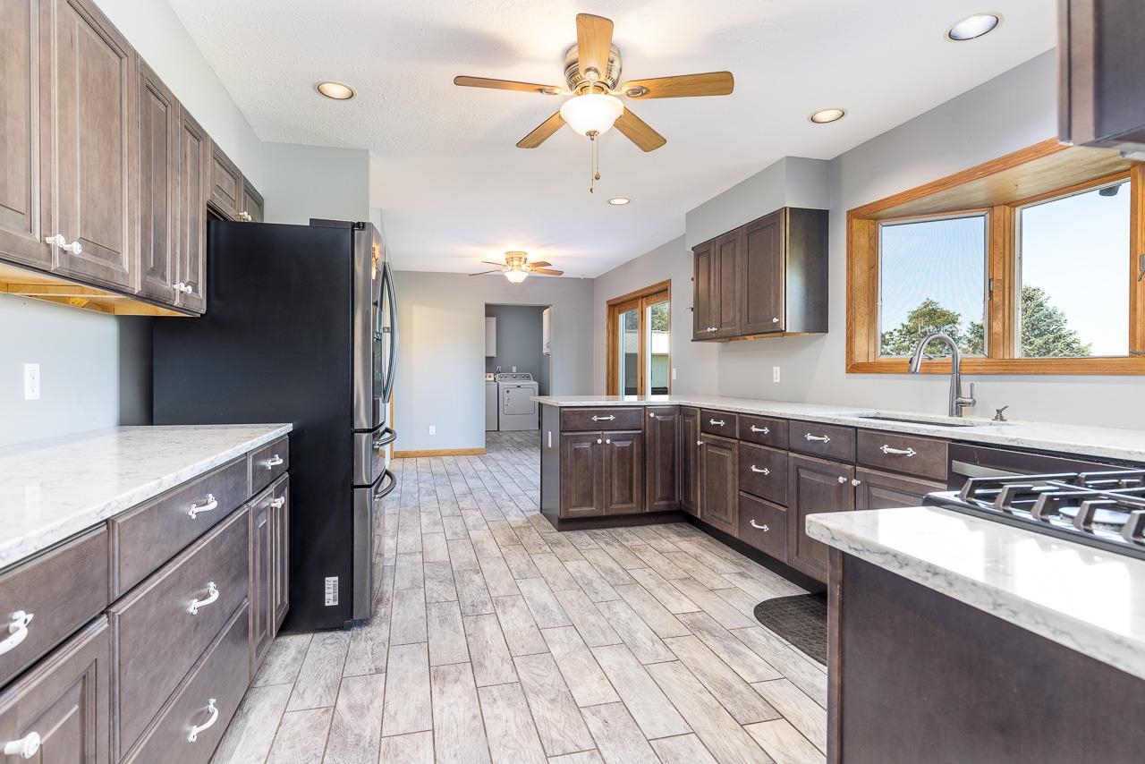 4661 North Marrill Road Byron, IL 61010 - Photo 8 of 39 a kitchen with stainless steel appliances a sink cabinets and wooden floor