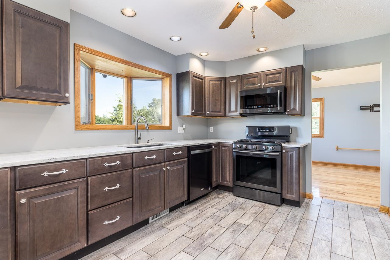4661 North Marrill Road Byron, IL 61010 - Photo 9 of 39 a large kitchen with stainless steel appliances granite countertop a stove and a sink