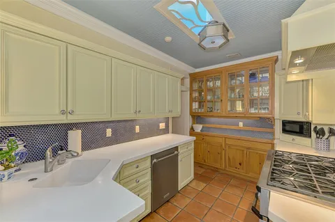 a kitchen with a sink cabinets and wooden floor
