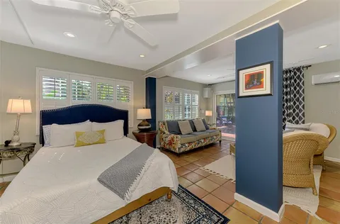 a bedroom with a bed a couch and a window