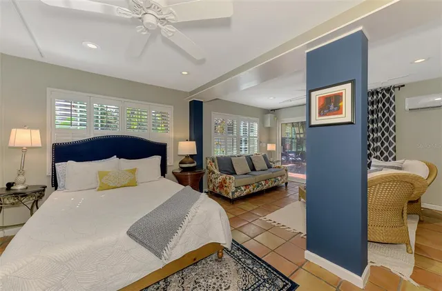 a bedroom with a bed a couch and a window