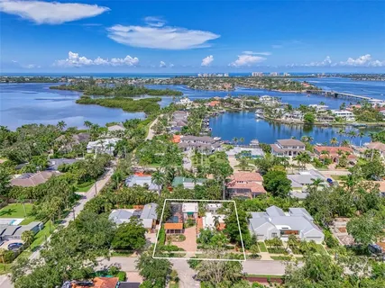 an aerial view of residential houses with outdoor space and ocean view